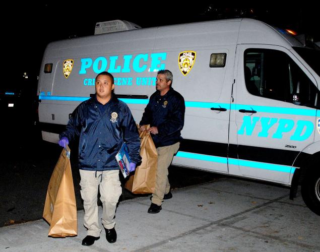 NYPD crime scene detectives carry bags of evidence found at the scene after Ashleigh Wade attacked expectant mother Angelikque Sutton and cut her baby girl out of her womb. 