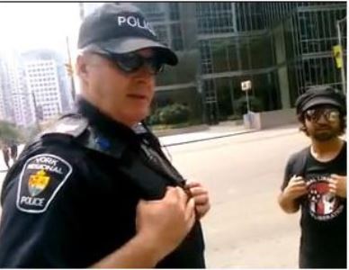 Sgt. Mark Charlebois is seen with G20 protester Paul Figueiras on June 27, 2010, on University Ave. near King St. W. Charlebois had asked to search Figueiras' backpack before letting him pass. Figueiras refused.